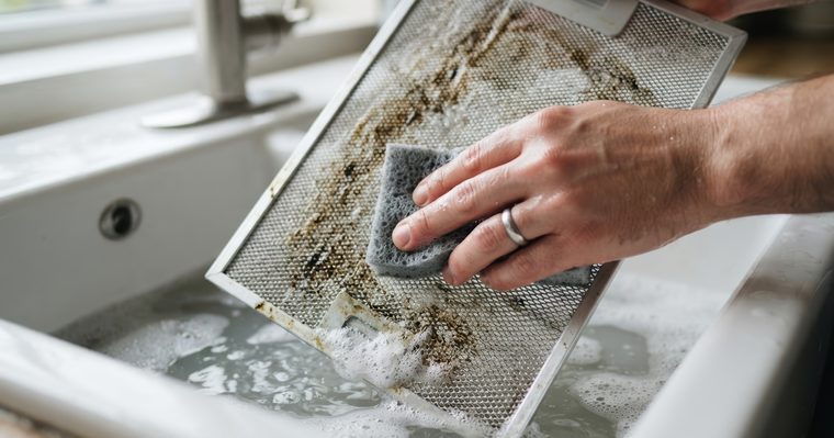Filtro metálico de la campana extractora cubierto de grasa