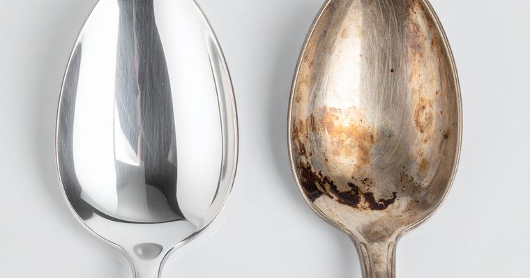 Cubertería de plata oscurecida junto a un paño de limpieza