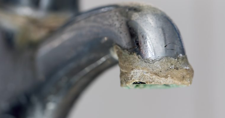 Cerco de cal blanca alrededor de la base de un grifo