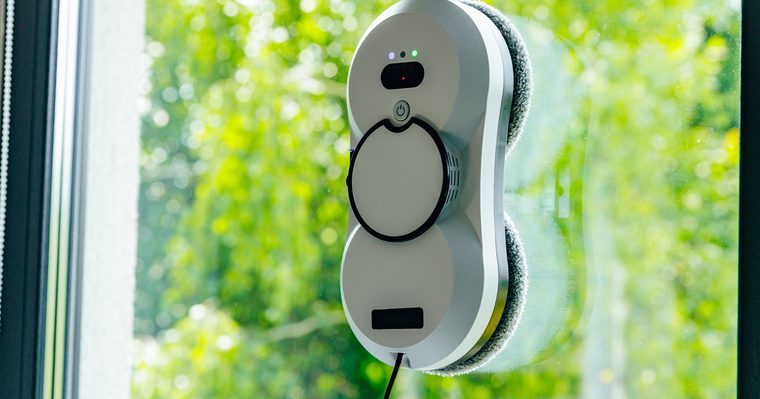Robot limpiacristales adherido a la hoja de una ventana